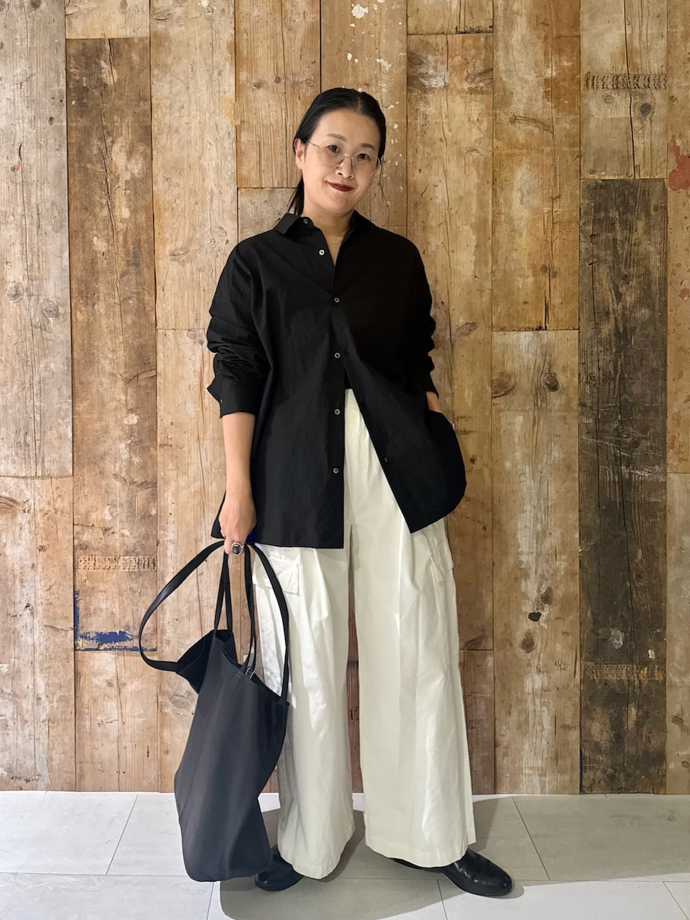 ホワイト系のその他パンツ、ブラック系のトートバッグ、ブラック系のシャツ/ブラウスを着用したレディースの秋コーディネートの4枚目の写真