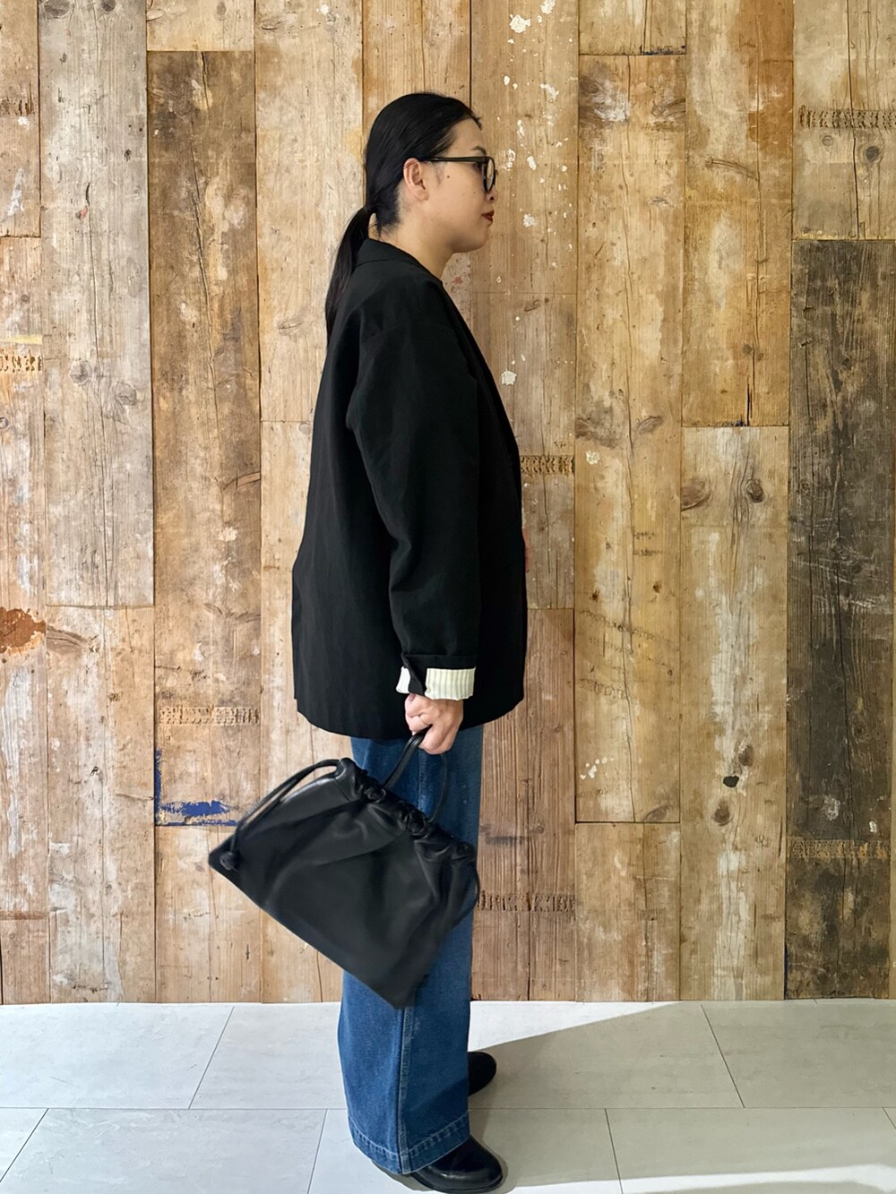 ブラック系のその他アウター、ホワイト系のキャミソール、ブルー系のデニムパンツを着用したレディースの秋コーディネートの2枚目の写真