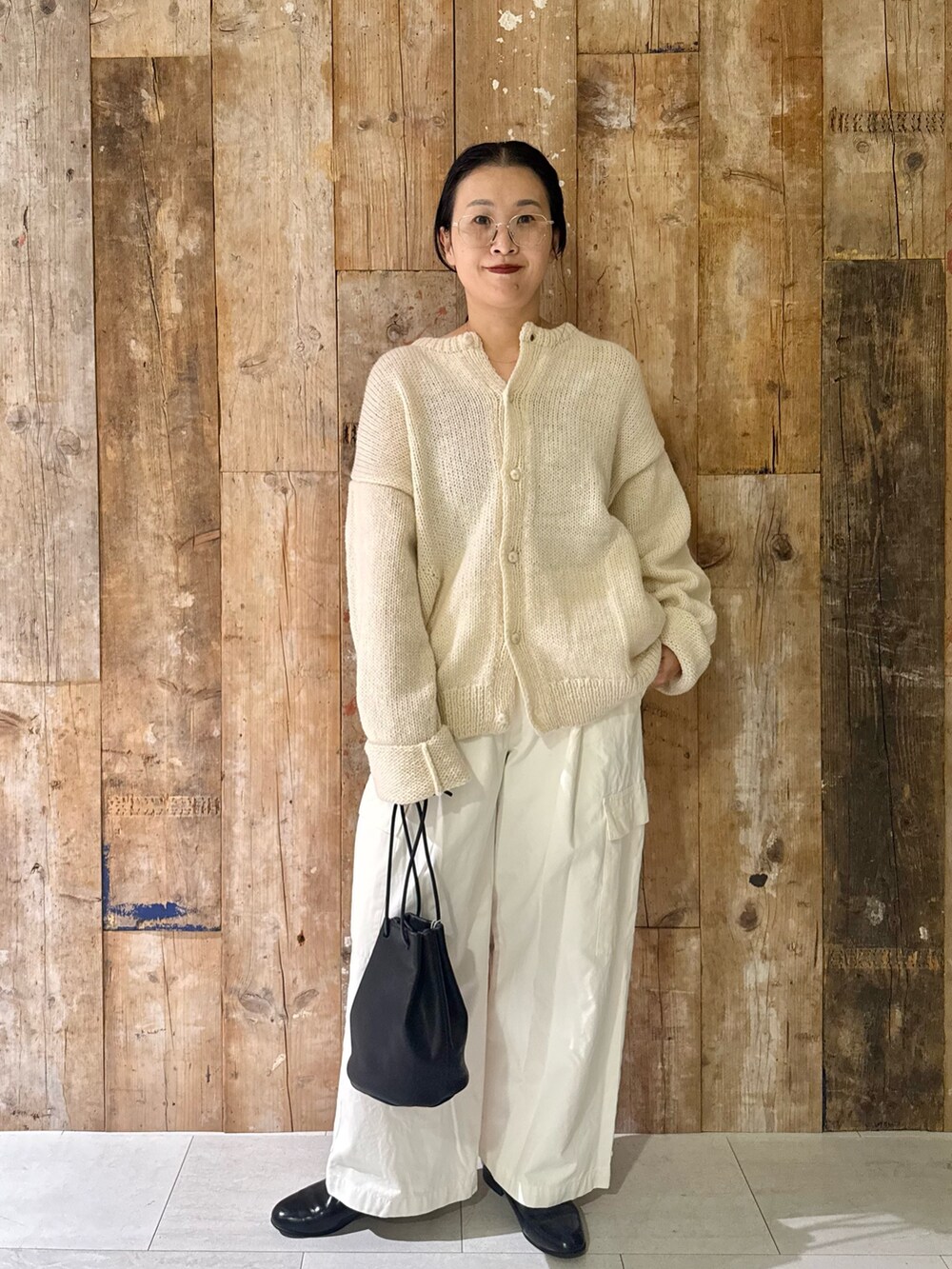 ホワイト系のその他パンツ、ホワイト系のニット/セーター、ブラック系のハンドバッグを着用したレディースの秋コーディネートの4枚目の写真