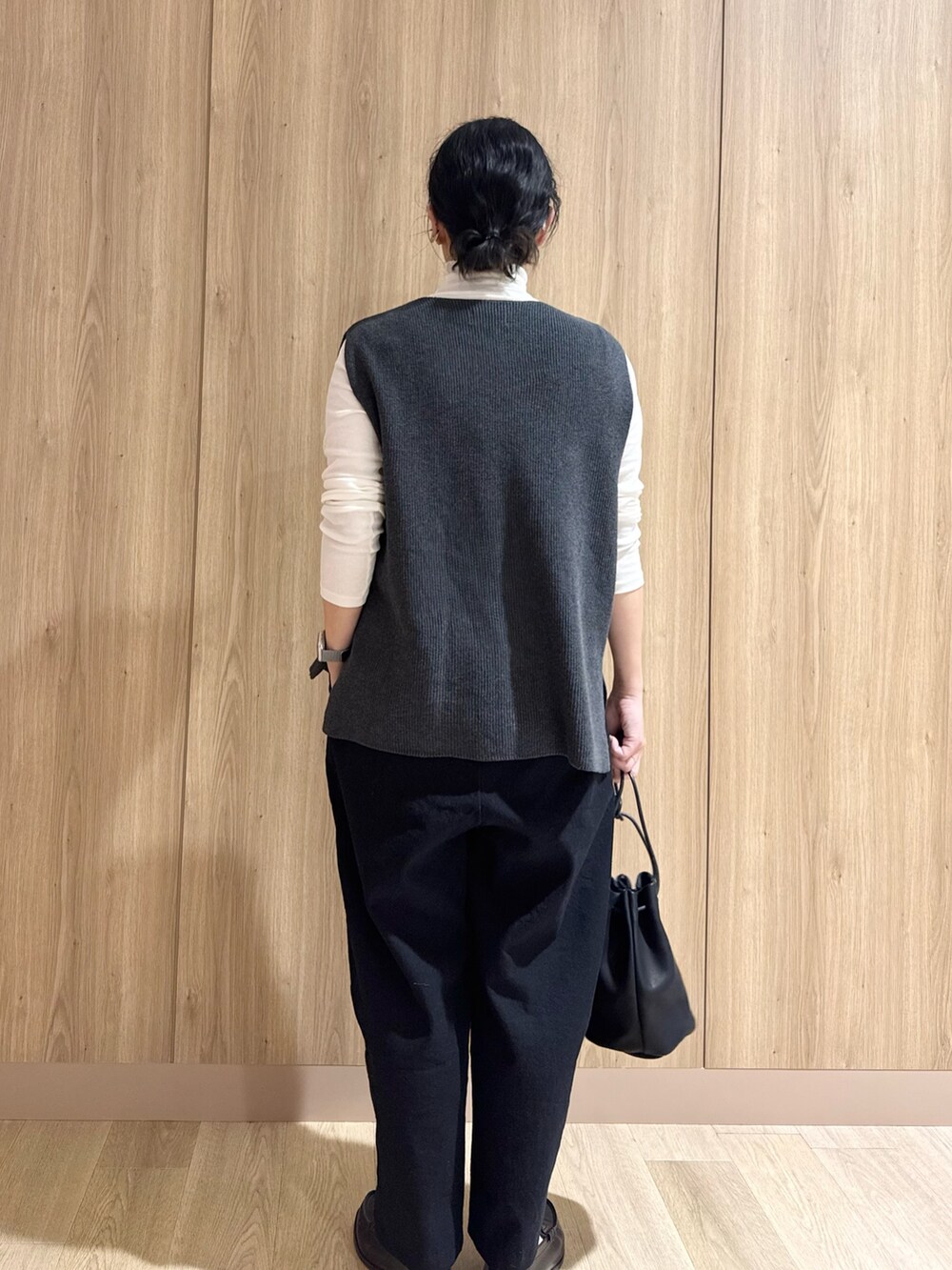 ホワイト系のTシャツ/カットソー、グレー系のベスト、ブラック系のその他パンツを着用したレディースの冬コーディネートの2枚目の写真