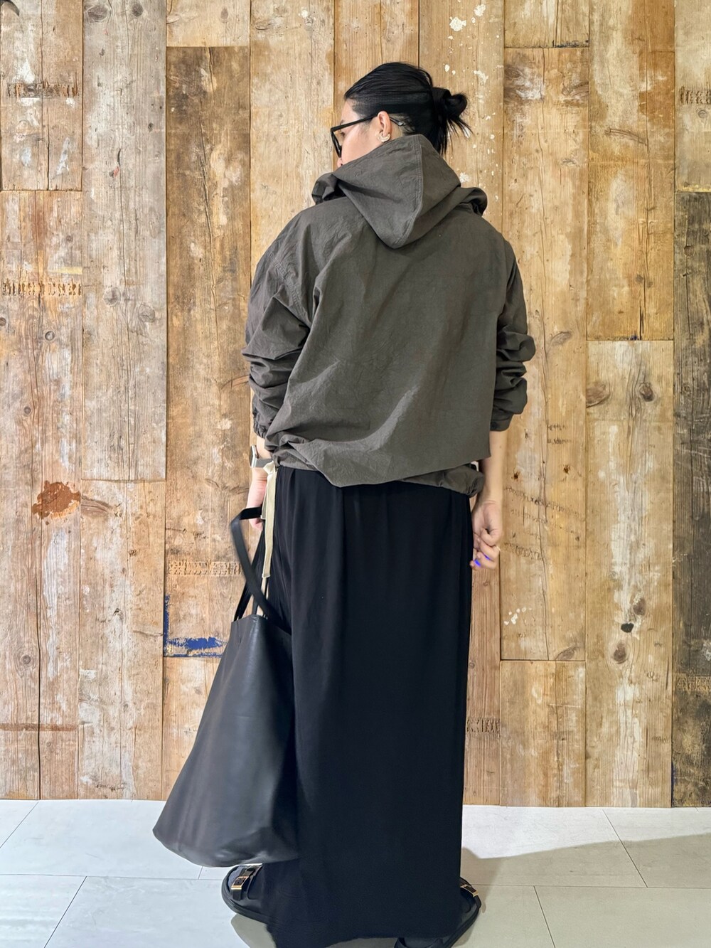 ブラック系のトートバッグ、ブラック系のワンピース、ブラック系のサンダルを着用したレディースの夏コーディネートの4枚目の写真