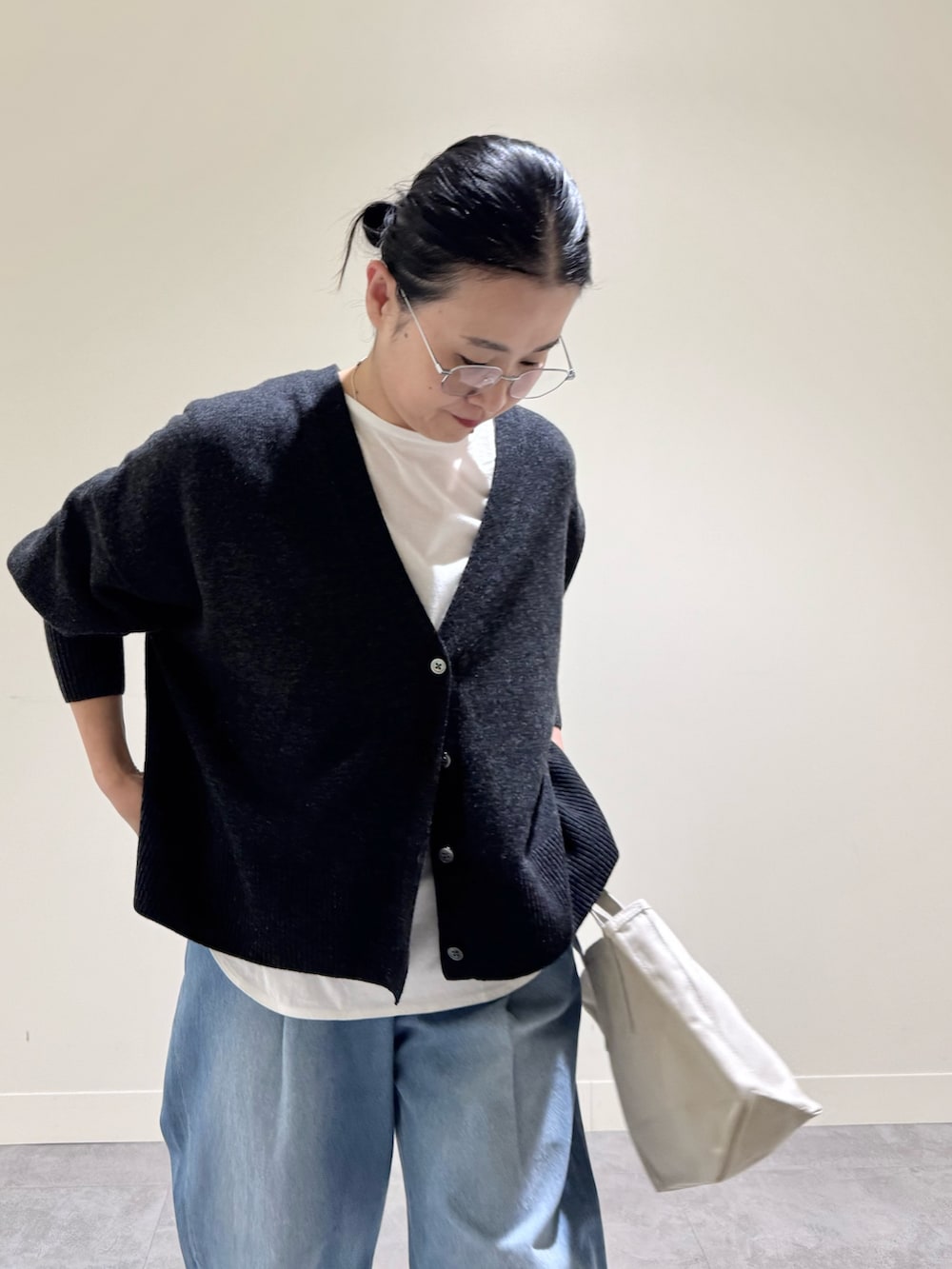 グレー系のカーディガン/ボレロ、ホワイト系のTシャツ/カットソー、ブルー系のデニムパンツを着用したレディースの冬コーディネートの2枚目の写真