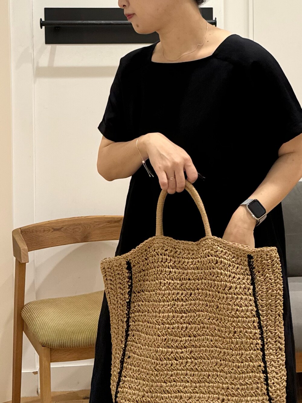 ブラック系のワンピース、ベージュ系のトートバッグ、ブラック系のサンダルを着用したレディースの夏コーディネートの2枚目の写真