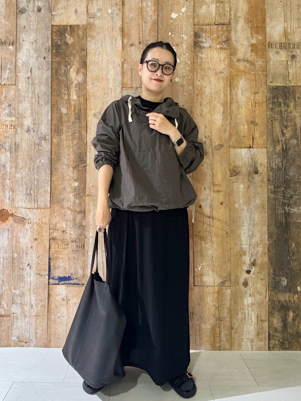 ブラック系のトートバッグ、ブラック系のワンピース、ブラック系のサンダルを着用したレディースの夏コーディネートの2枚目の写真