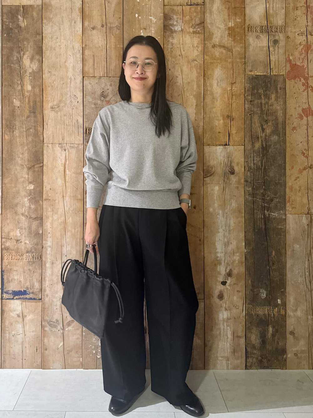 ブルー系のステンカラーコート、グレー系のTシャツ/カットソー、ブラック系のその他パンツを着用したレディースの冬コーディネートの3枚目の写真