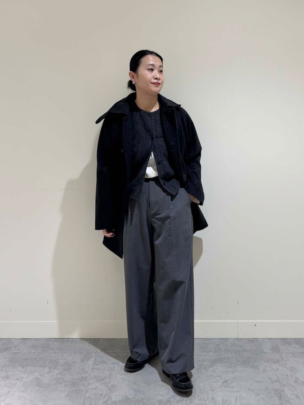 グレー系のピーコート、グレー系のその他パンツ、ホワイト系のTシャツ/カットソーを着用したレディースの冬コーディネートの5枚目の写真