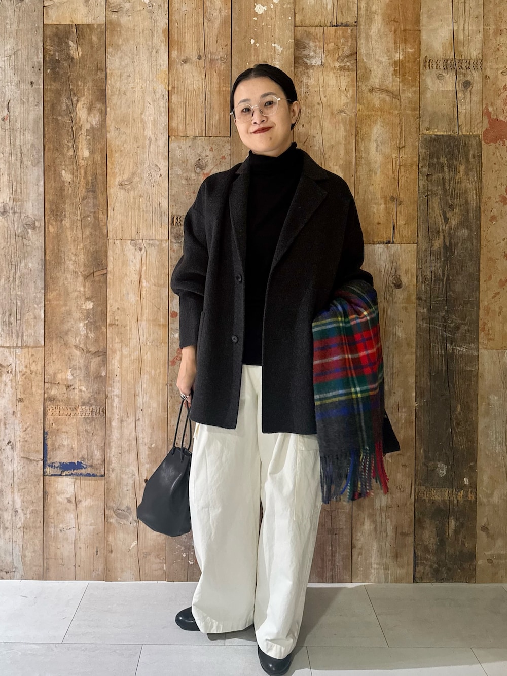 ブラック系のニット/セーター、グレー系のその他アウター、ブラック系のバッグを着用したレディースの秋コーディネートの2枚目の写真