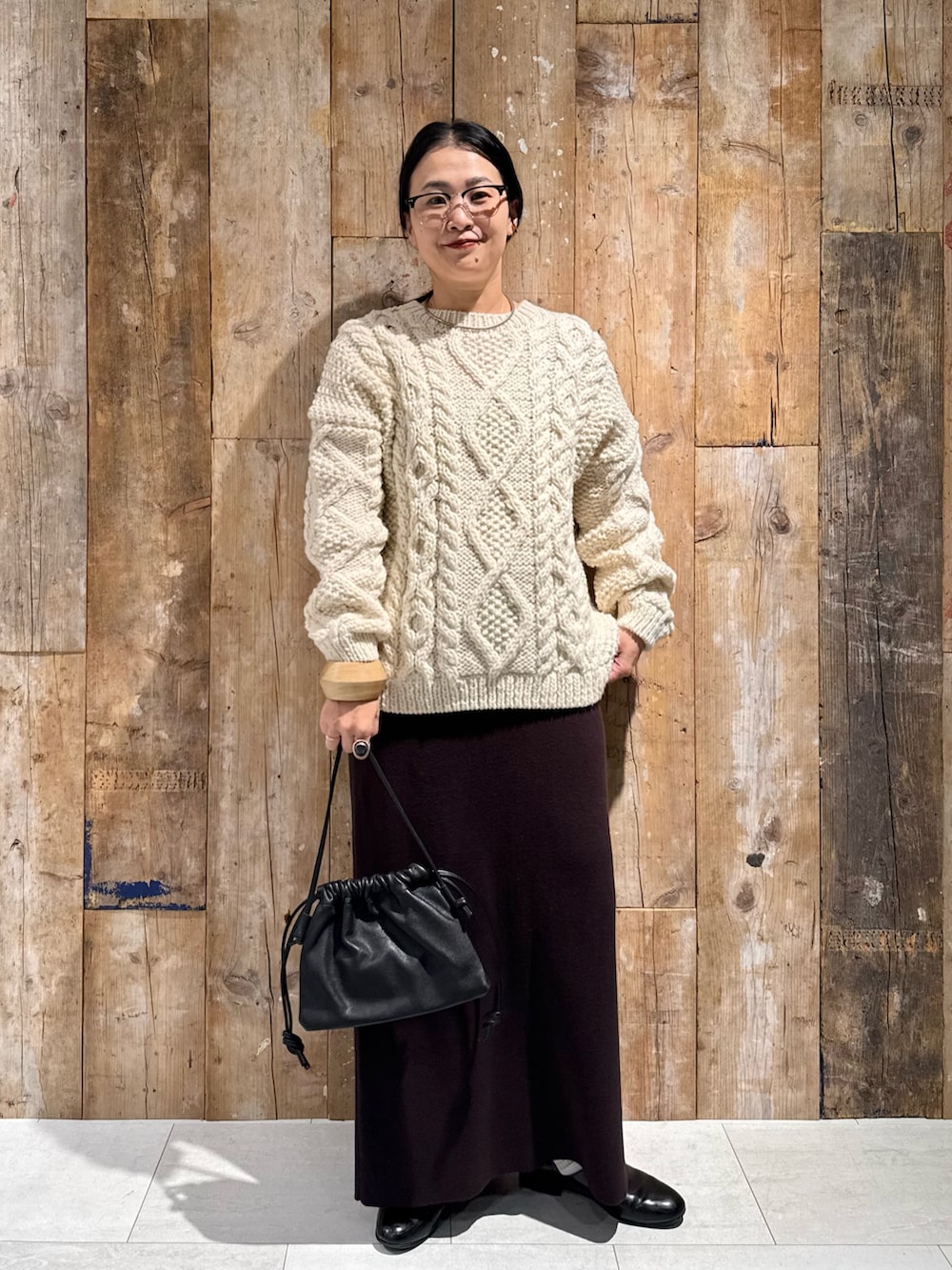 ホワイト系のニット/セーター、ブラウン系のスカート、ブラック系のショルダーバッグを着用したレディースの秋コーディネートの5枚目の写真