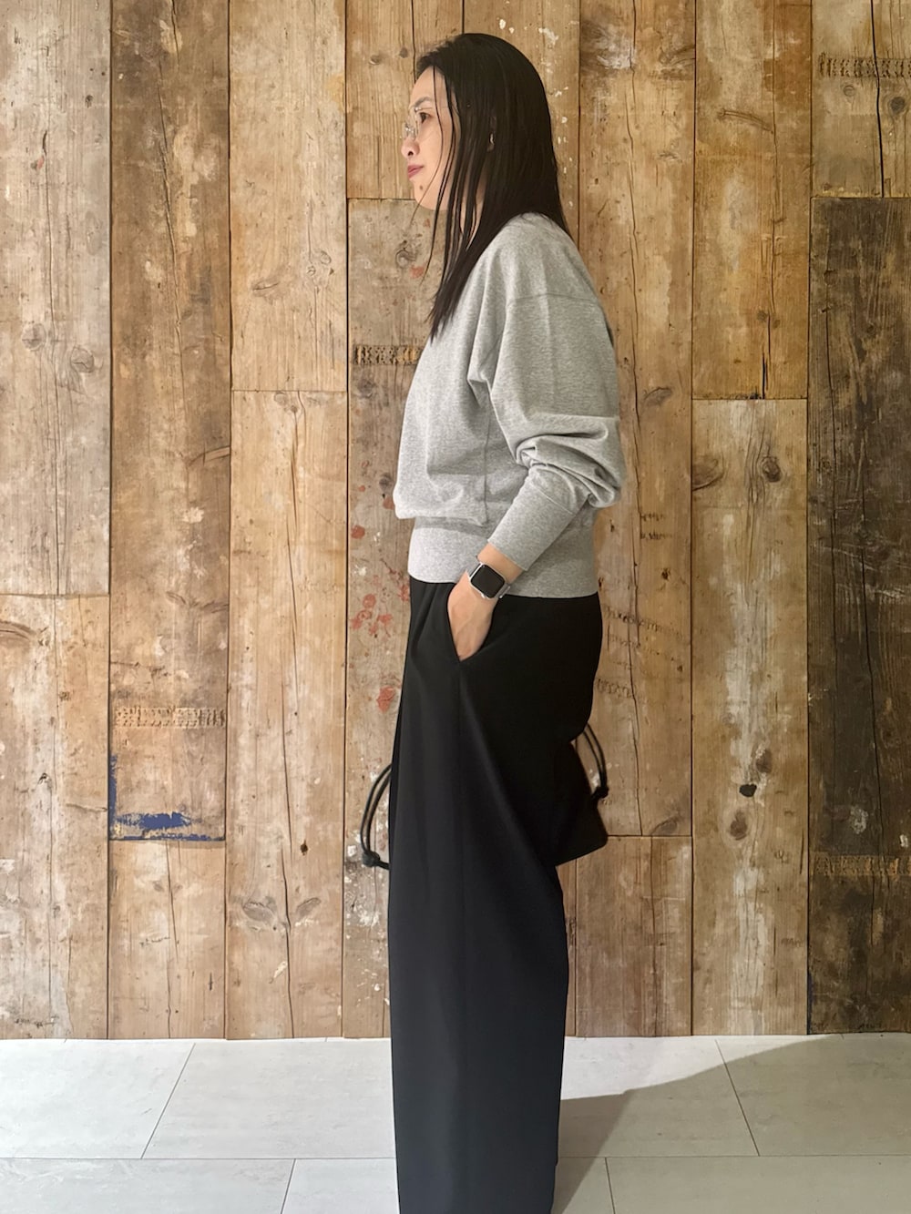 ブルー系のステンカラーコート、グレー系のTシャツ/カットソー、ブラック系のその他パンツを着用したレディースの冬コーディネートの4枚目の写真