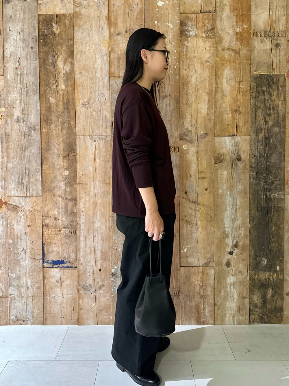 ブラック系のバッグ、ブルー系のその他パンツ、ブラウン系のTシャツ/カットソーを着用したレディースの秋コーディネートの2枚目の写真