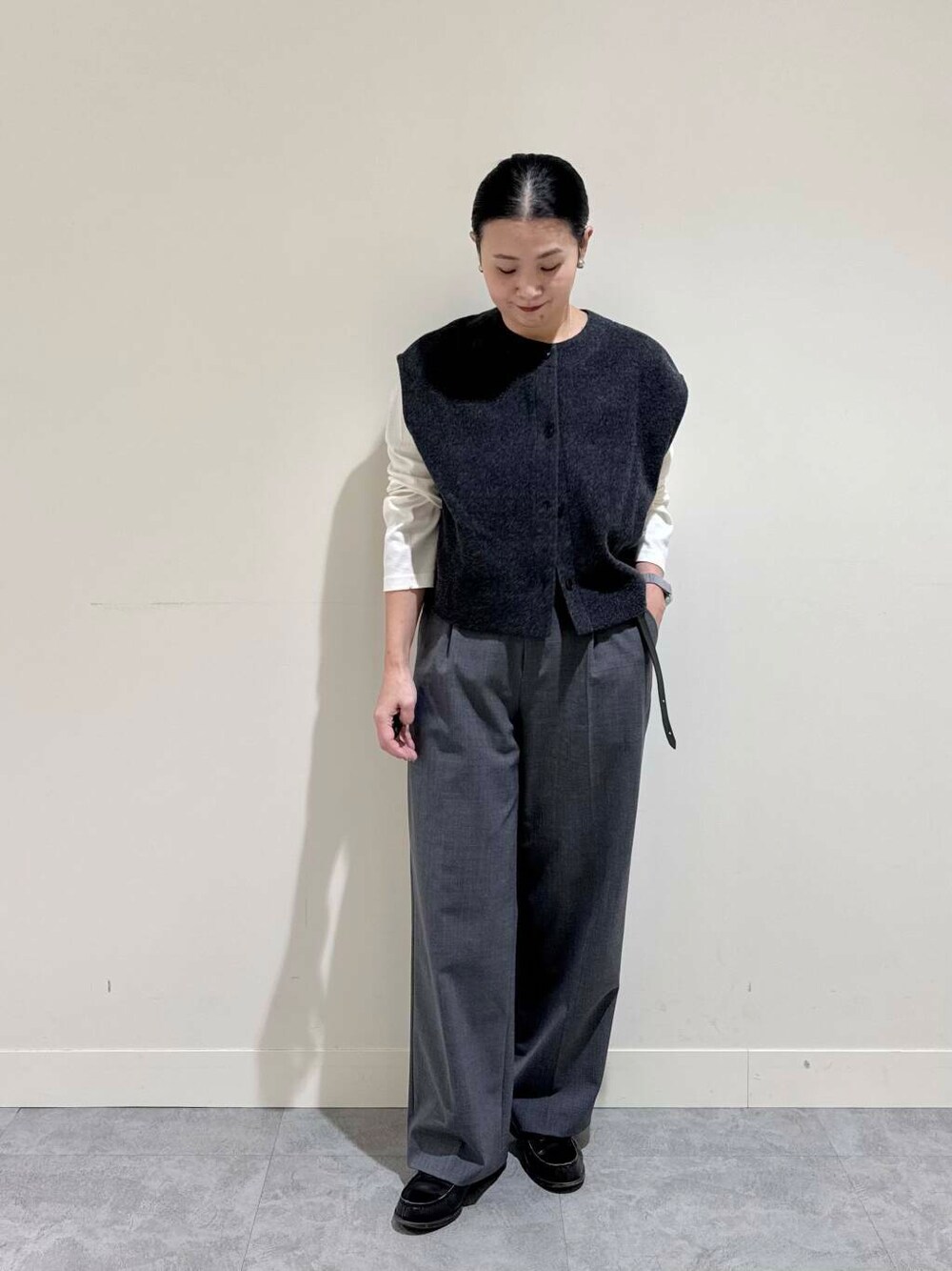 グレー系のピーコート、グレー系のその他パンツ、ホワイト系のTシャツ/カットソーを着用したレディースの冬コーディネートの2枚目の写真