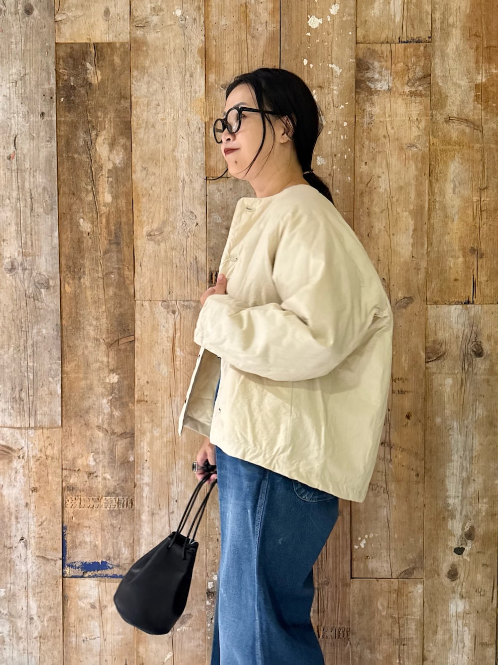 ホワイト系のジャケット/アウター、ブラック系のTシャツ/カットソー、ブルー系のデニムパンツを着用したレディースの秋コーディネートの2枚目の写真