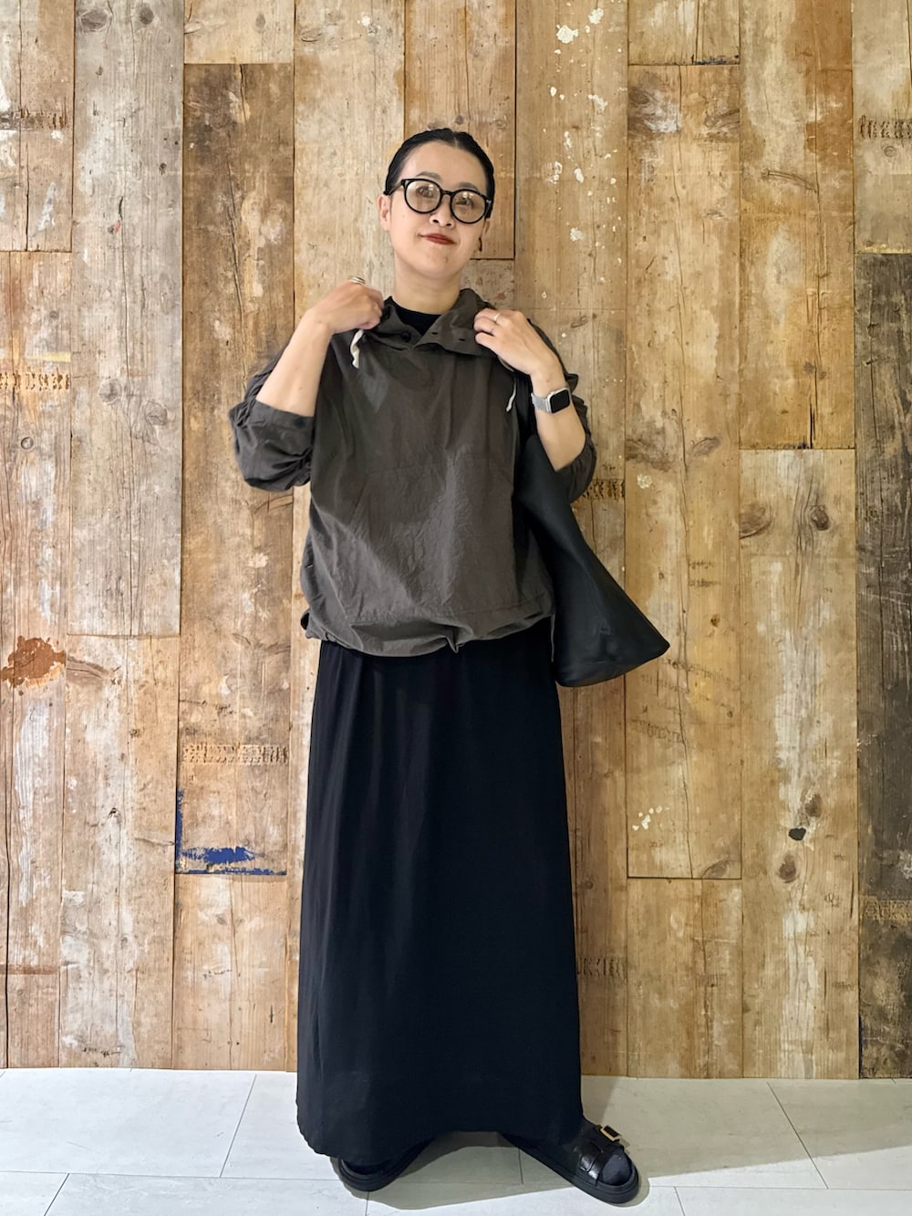 ブラック系のトートバッグ、ブラック系のワンピース、ブラック系のサンダルを着用したレディースの夏コーディネートの3枚目の写真