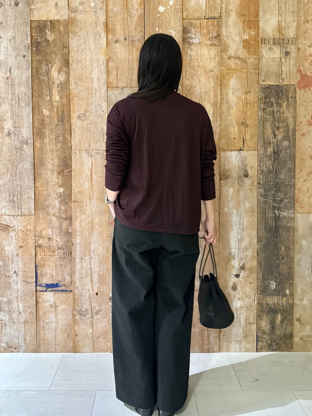 ブラック系のバッグ、ブルー系のその他パンツ、ブラウン系のTシャツ/カットソーを着用したレディースの秋コーディネートの3枚目の写真