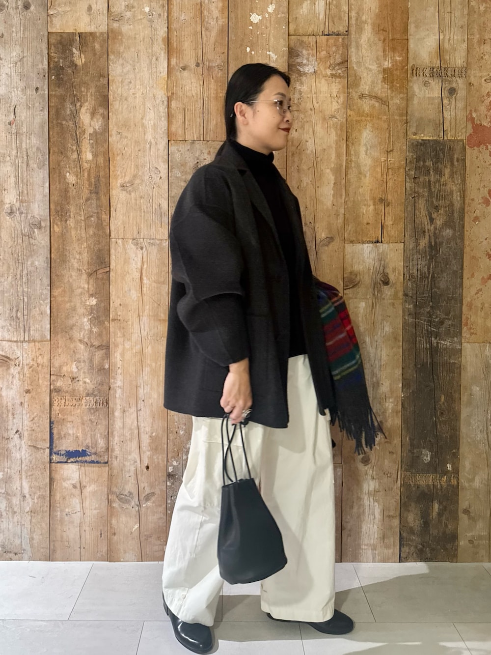 ブラック系のニット/セーター、グレー系のその他アウター、ブラック系のバッグを着用したレディースの秋コーディネートの4枚目の写真