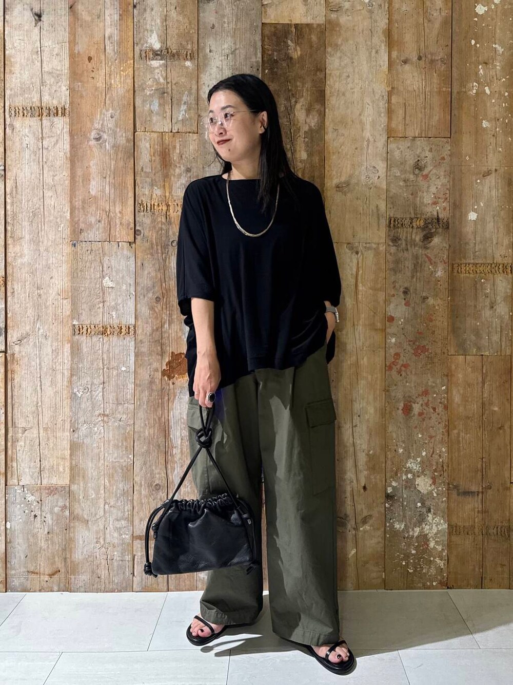 グリーン系のその他パンツ、ブラック系のTシャツ/カットソーを着用したレディースの夏コーディネートの4枚目の写真