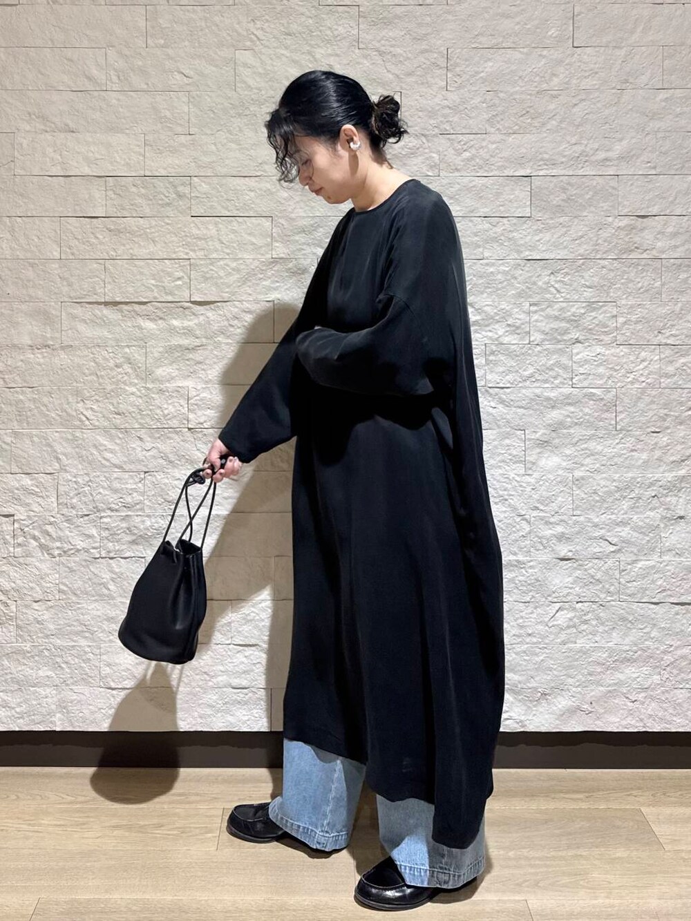ブルー系のデニムパンツ、ブラック系のワンピースを着用したレディースの冬コーディネートの3枚目の写真