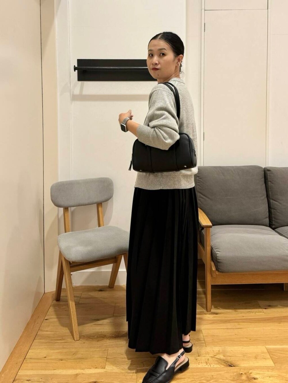 ブラック系のスカート、ブラック系のサンダル、ブラック系のボストンバッグを着用したレディースの夏コーディネートの2枚目の写真