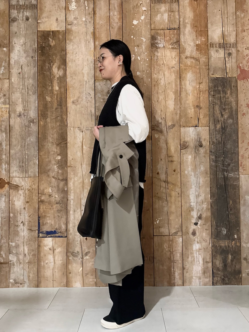 ホワイト系のTシャツ/カットソー、ブラック系のベスト、ブラック系のその他パンツを着用したレディースの冬コーディネートの2枚目の写真