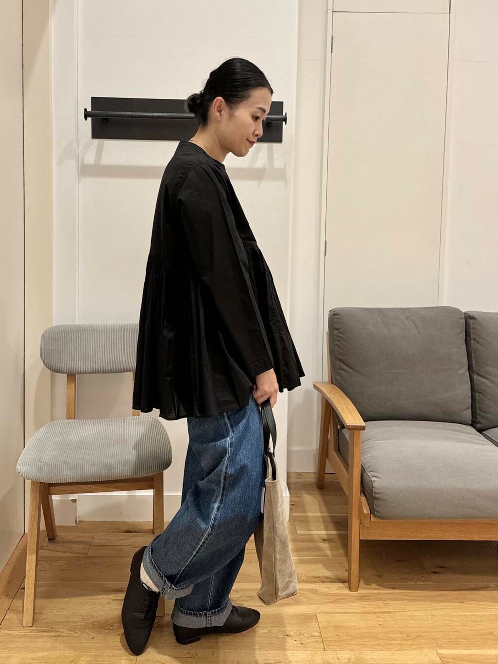 ブルー系のデニムパンツ、ベージュ系のトートバッグ、ブラック系のその他シューズを着用したレディースの秋コーディネートの4枚目の写真