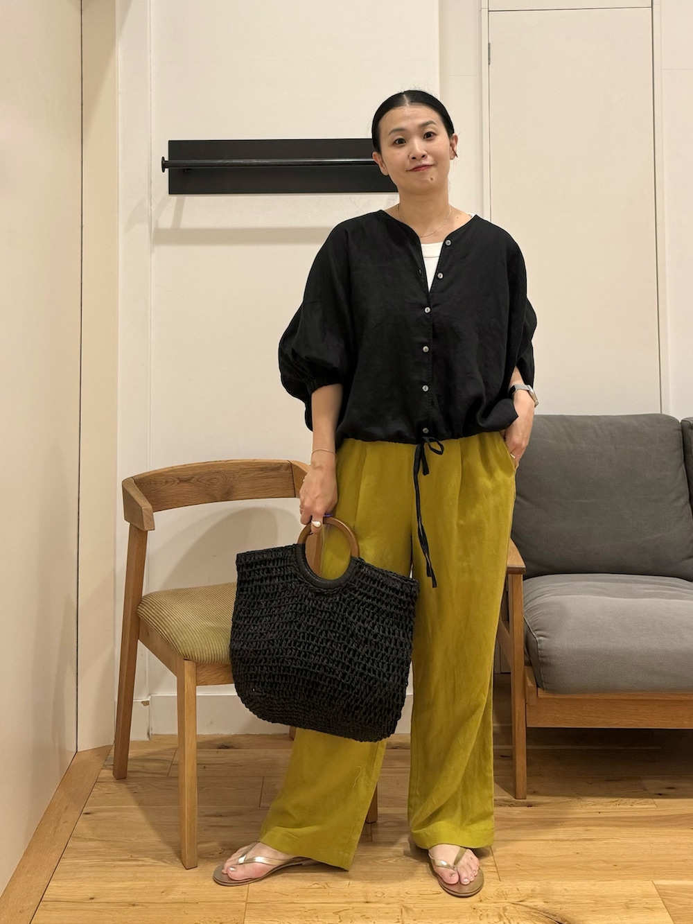 ブラック系のシャツ/ブラウス、イエロー系のその他パンツ、ブラック系のかごバッグを着用したレディースの夏コーディネートの2枚目の写真