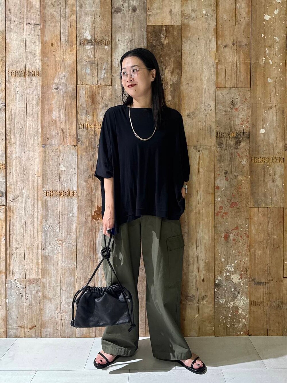 グリーン系のその他パンツ、ブラック系のTシャツ/カットソーを着用したレディースの夏コーディネートの2枚目の写真