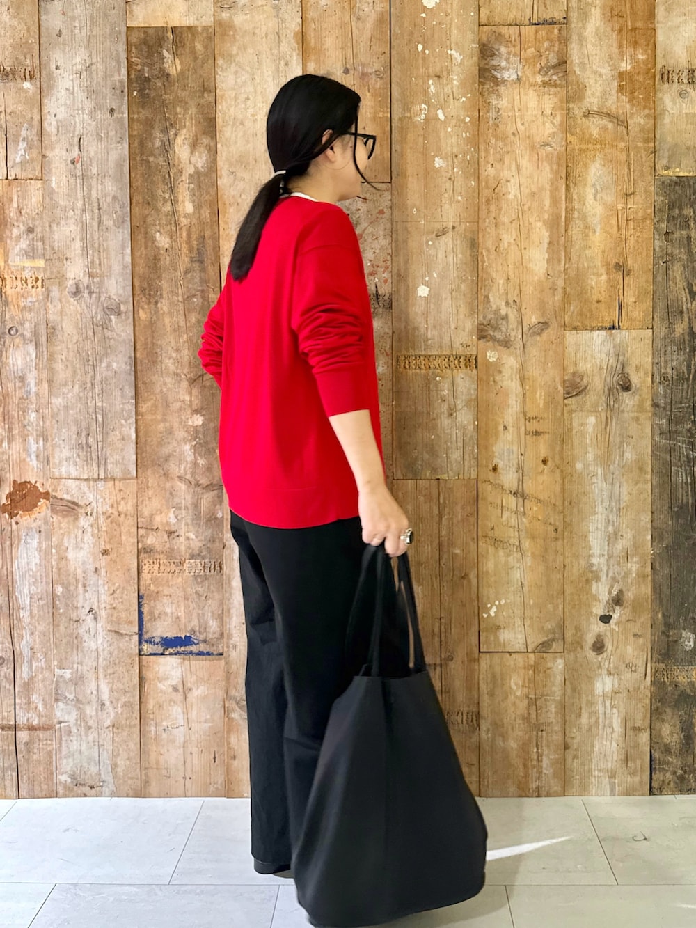 レッド系のニット/セーター、ホワイト系のTシャツ/カットソー、ブラック系のその他パンツを着用したレディースの秋コーディネートの3枚目の写真