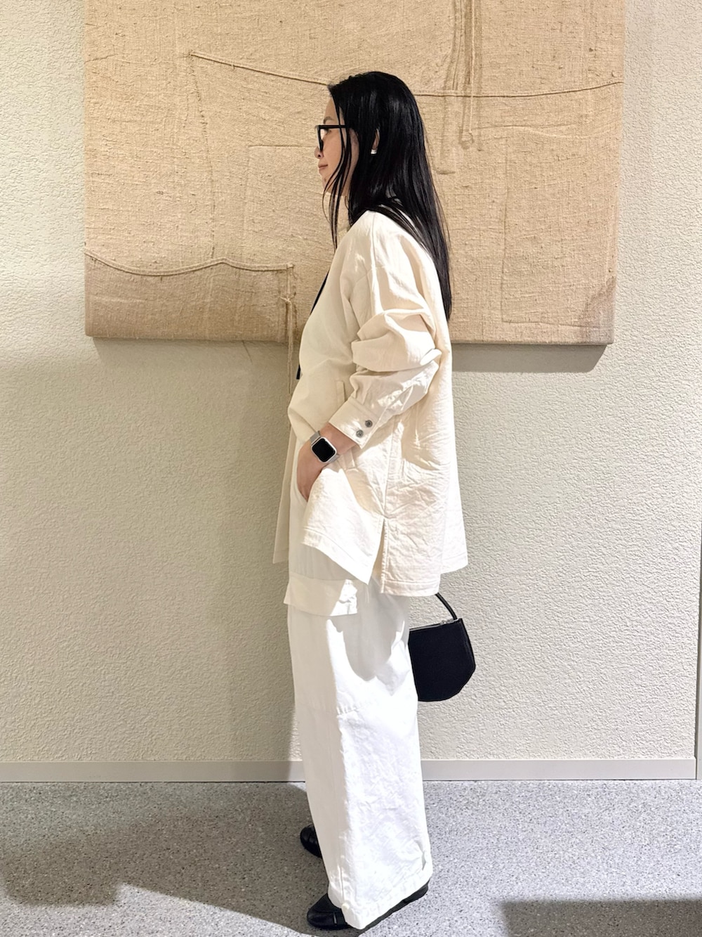 ホワイト系のその他アウター、ホワイト系のその他パンツ、ブラック系のハンドバッグを着用したレディースの春コーディネートの2枚目の写真