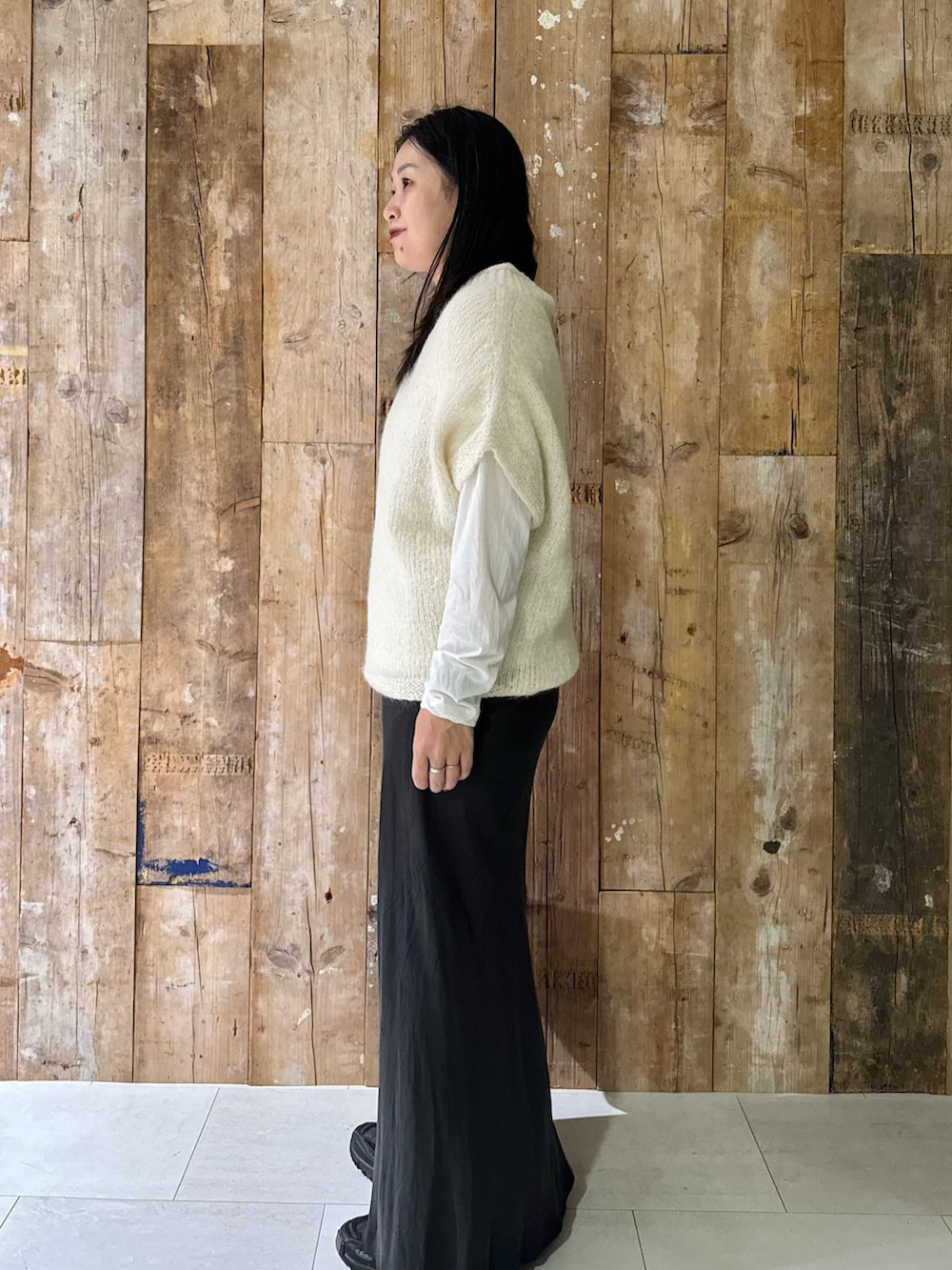 ホワイト系のTシャツ/カットソー、ホワイト系のニット/セーター、グレー系のスカートを着用したレディースの秋コーディネートの2枚目の写真