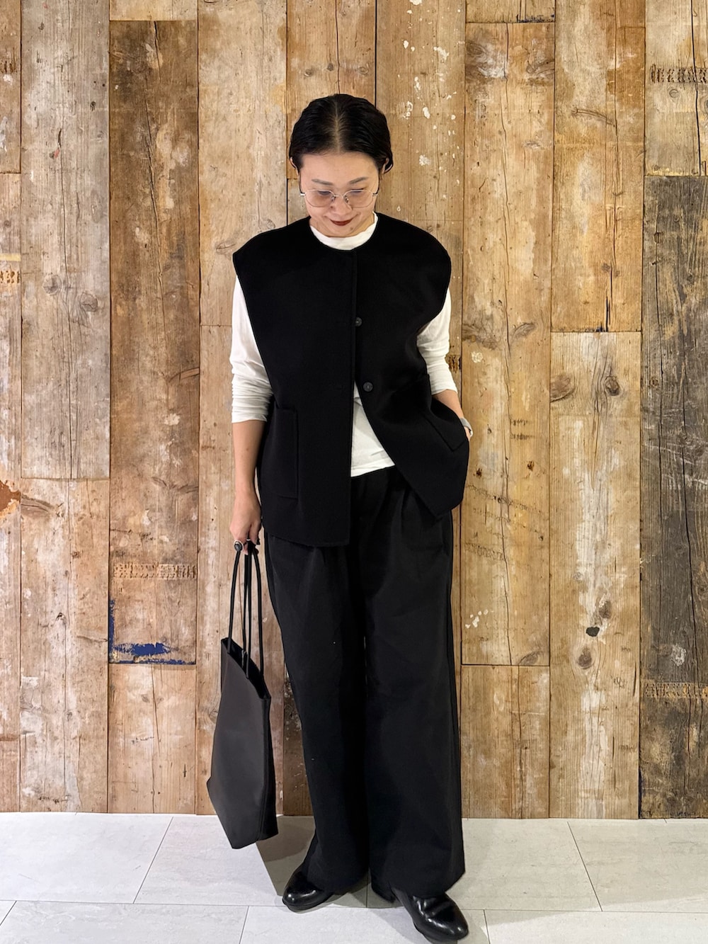 ブラック系のその他アウター、ホワイト系のTシャツ/カットソー、ブラック系のその他パンツを着用したレディースの秋コーディネートの2枚目の写真