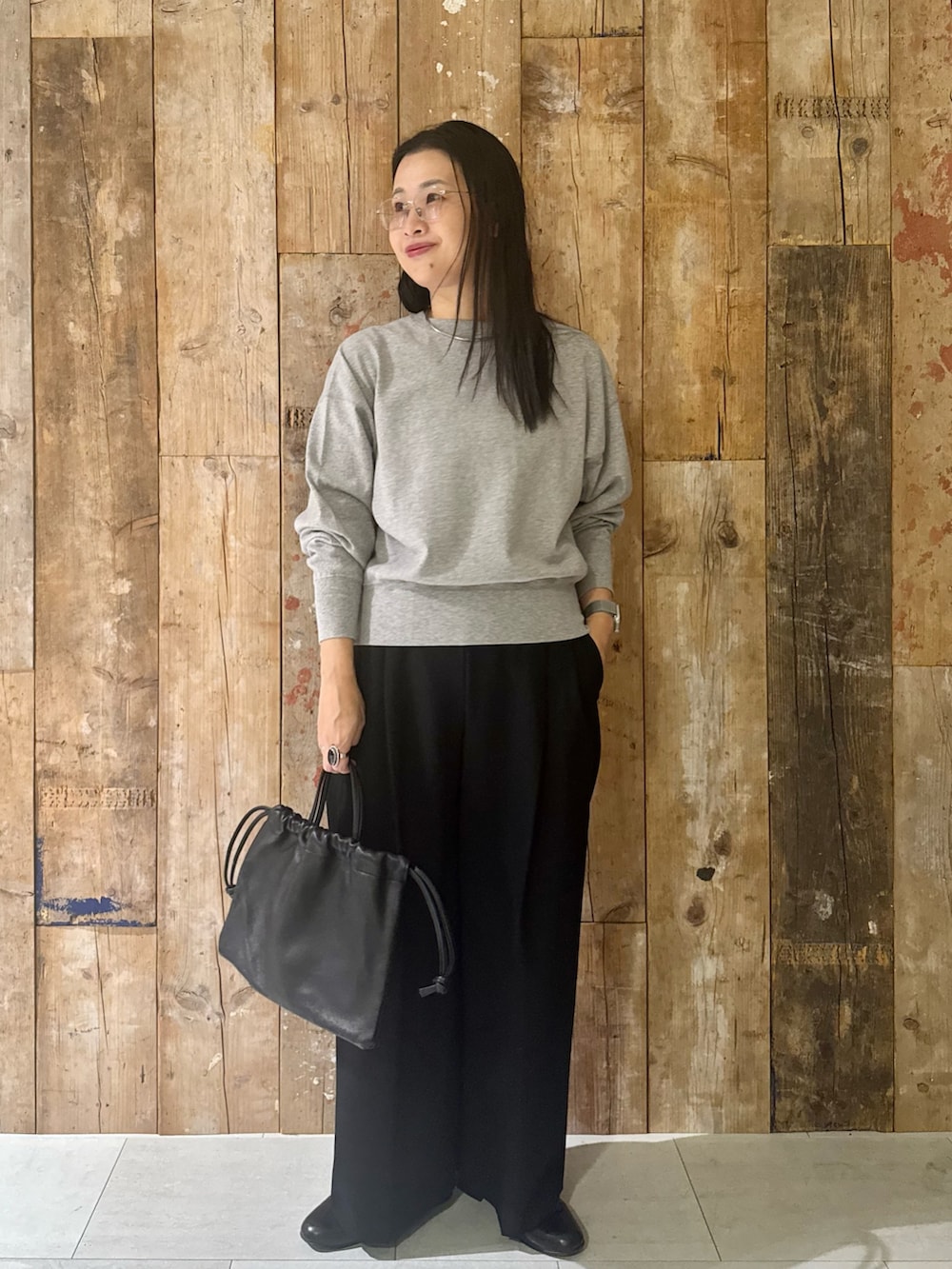 ブルー系のステンカラーコート、グレー系のTシャツ/カットソー、ブラック系のその他パンツを着用したレディースの冬コーディネートの5枚目の写真