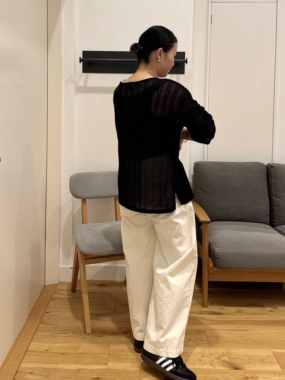 ブラック系のショルダーバッグ、ブラック系のスニーカー、ブラック系のニット/セーターを着用したレディースの夏コーディネートの2枚目の写真