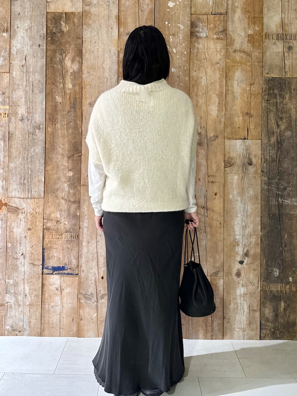 ホワイト系のTシャツ/カットソー、ホワイト系のニット/セーター、グレー系のスカートを着用したレディースの秋コーディネートの3枚目の写真