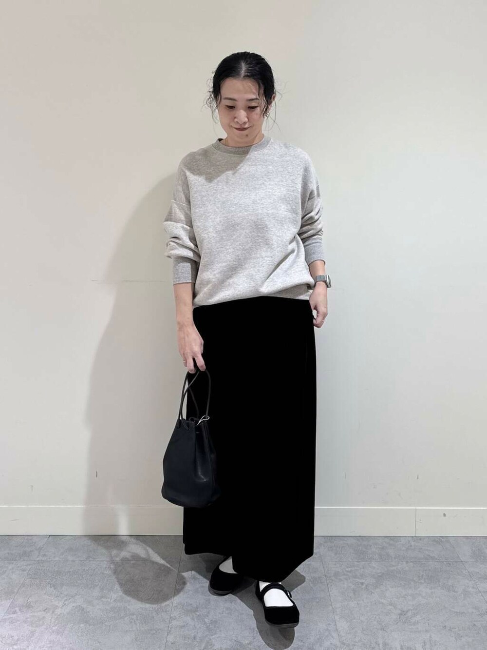 ブラック系のスカート、グレー系のスウェット、ブラック系のその他雑貨を着用したレディースの冬コーディネートの2枚目の写真