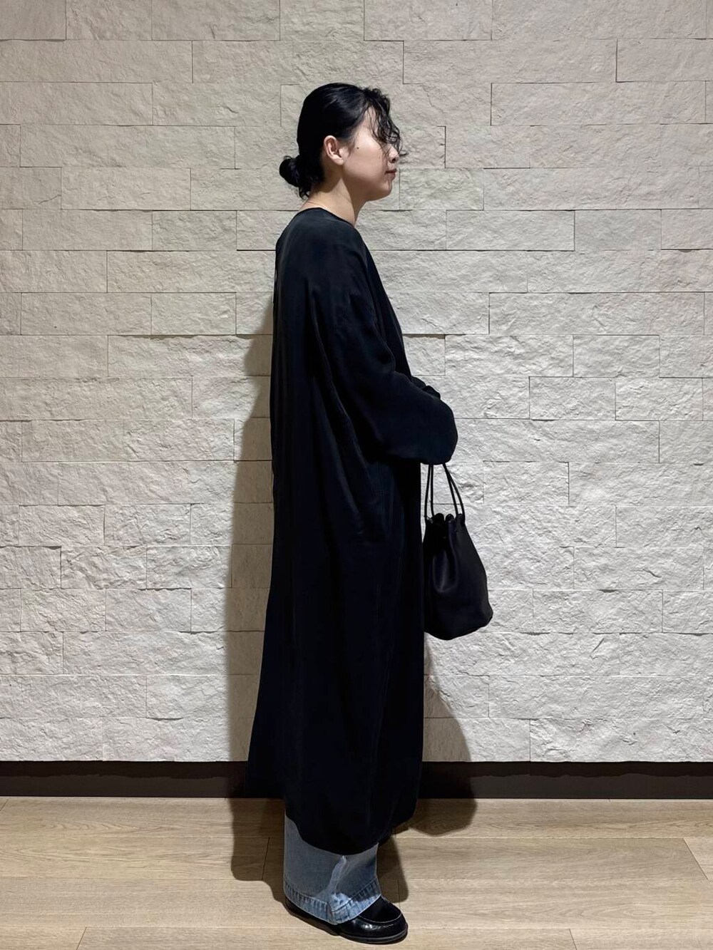 ブルー系のデニムパンツ、ブラック系のワンピースを着用したレディースの冬コーディネートの4枚目の写真