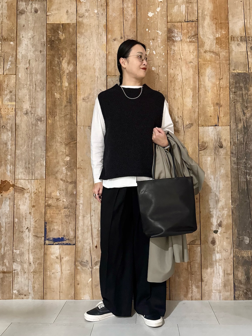 ホワイト系のTシャツ/カットソー、ブラック系のベスト、ブラック系のその他パンツを着用したレディースの冬コーディネートの4枚目の写真