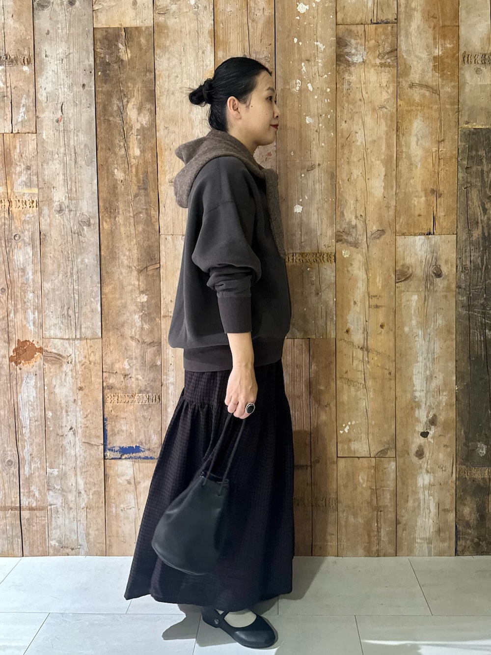 グレー系のスウェット、ブラウン系のスカート、ブラック系のバレエシューズを着用したレディースの冬コーディネートの4枚目の写真