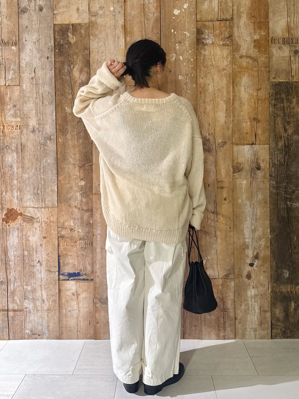 ホワイト系のその他パンツ、ホワイト系のニット/セーター、ブラック系のハンドバッグを着用したレディースの秋コーディネートの3枚目の写真
