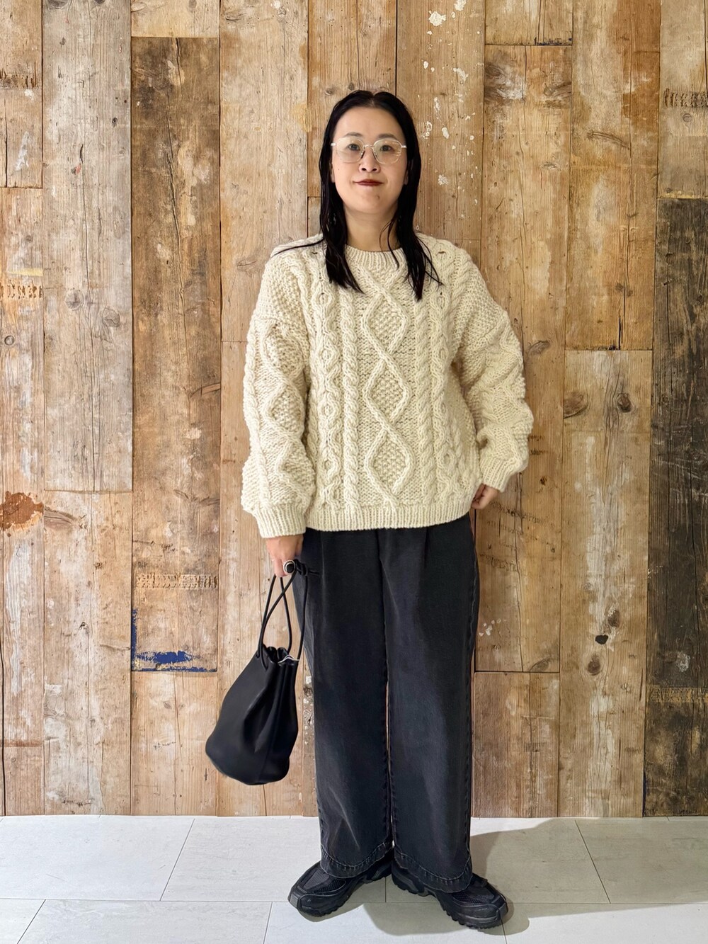 ホワイト系のニット/セーター、ブラック系のデニムパンツ、ブラック系のバッグを着用したレディースの秋コーディネートの2枚目の写真