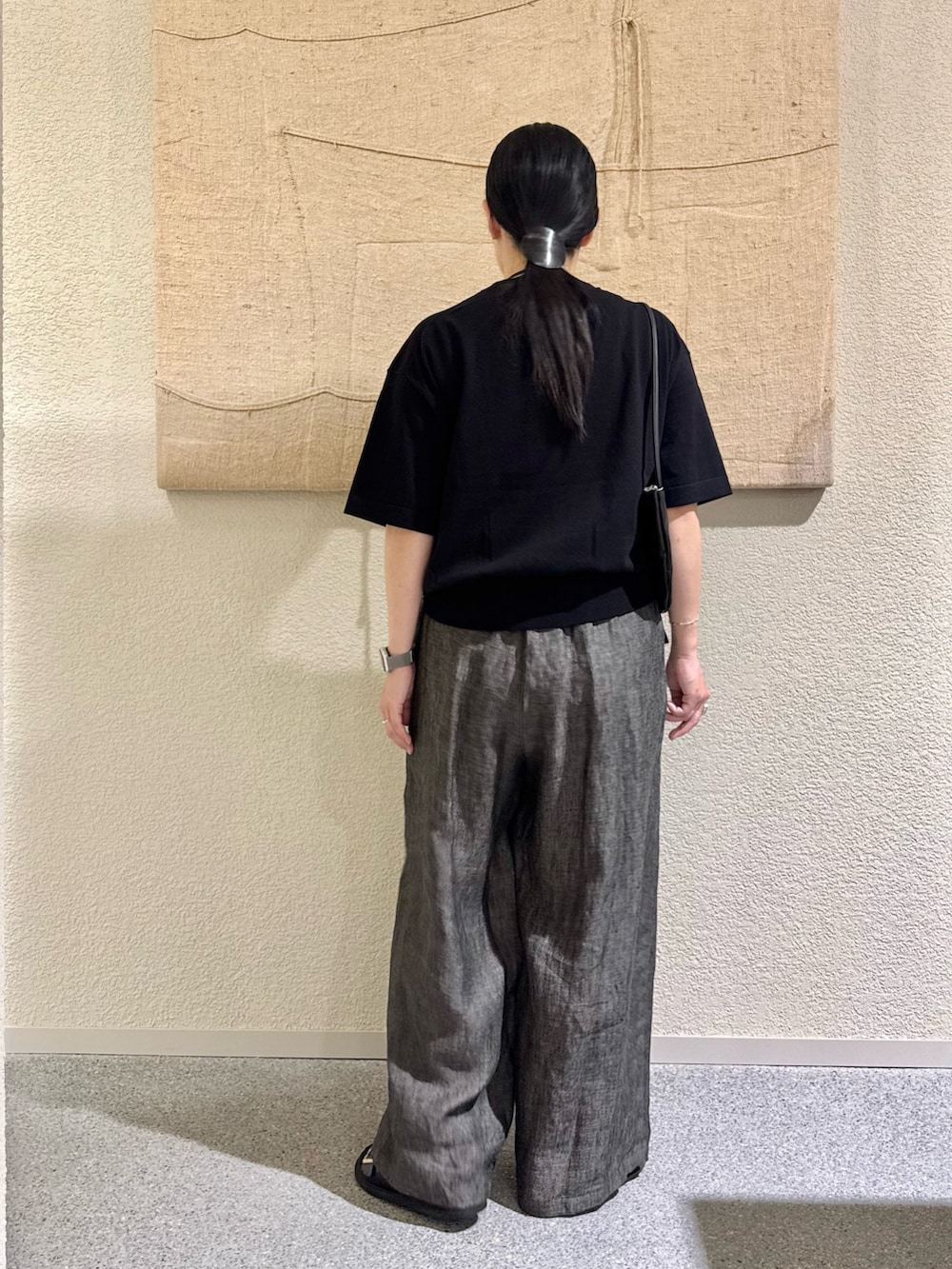 ブラック系のニット/セーター、ブラック系のパンツ、ブラック系のハンドバッグを着用したレディースの春コーディネートの2枚目の写真