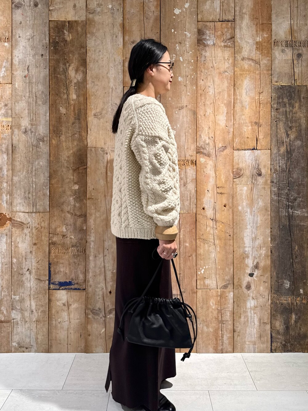 ホワイト系のニット/セーター、ブラウン系のスカート、ブラック系のショルダーバッグを着用したレディースの秋コーディネートの4枚目の写真