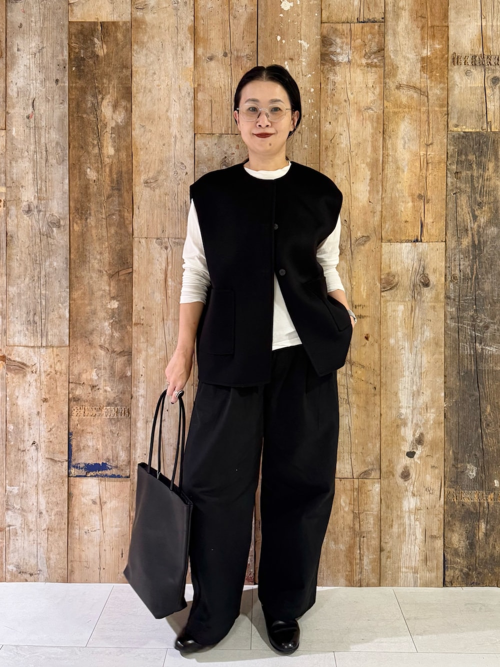 ブラック系のその他アウター、ホワイト系のTシャツ/カットソー、ブラック系のその他パンツを着用したレディースの秋コーディネートの4枚目の写真