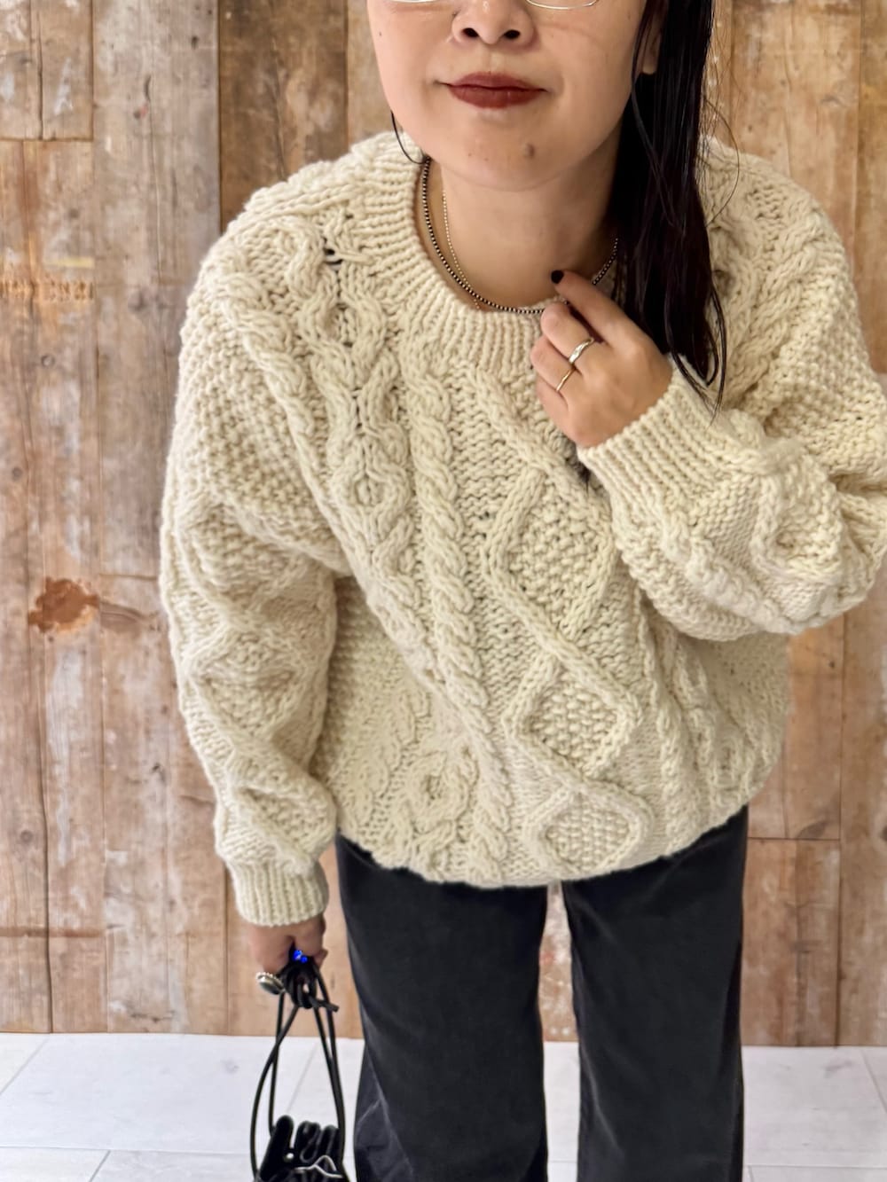 ホワイト系のニット/セーター、ブラック系のデニムパンツ、ブラック系のバッグを着用したレディースの秋コーディネートの3枚目の写真