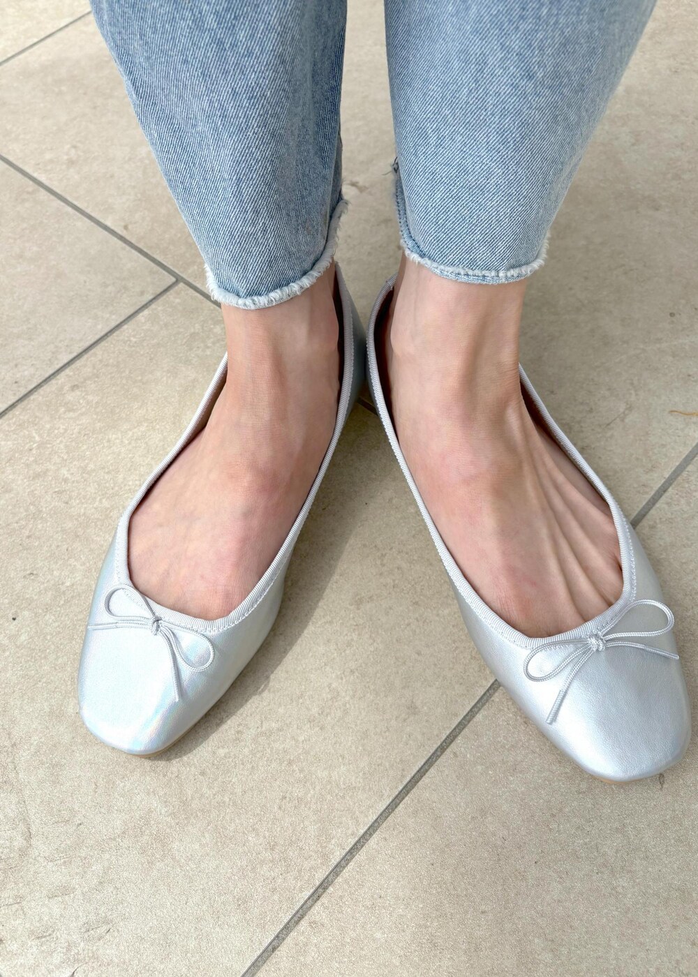 ブルー系のシャツ/ブラウス、グレー系のその他パンツ、ホワイト系のハンドバッグを着用したレディースの春コーディネートの6枚目の写真