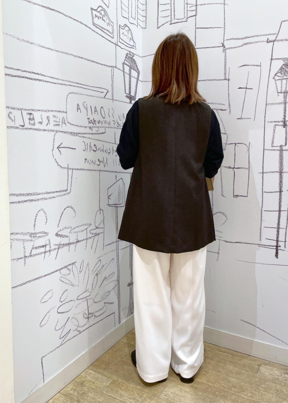 ブラック系のニット/セーター、ブラウン系のベスト、ブラウン系のショルダーバッグを着用したレディースの冬コーディネートの2枚目の写真