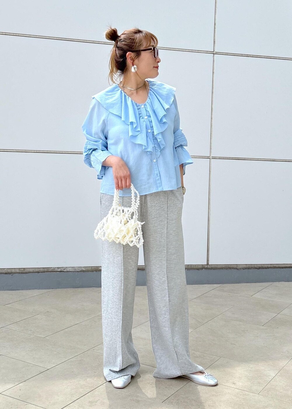 ブルー系のシャツ/ブラウス、グレー系のその他パンツ、ホワイト系のハンドバッグを着用したレディースの春コーディネートの2枚目の写真