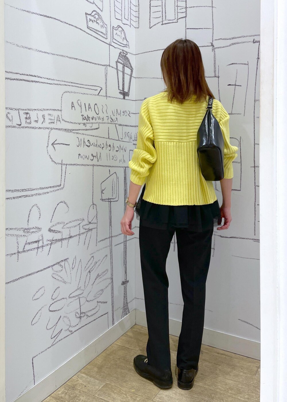 イエロー系のニット/セーター、ブラック系のその他パンツ、ブラック系のベストを着用したレディースの冬コーディネートの3枚目の写真