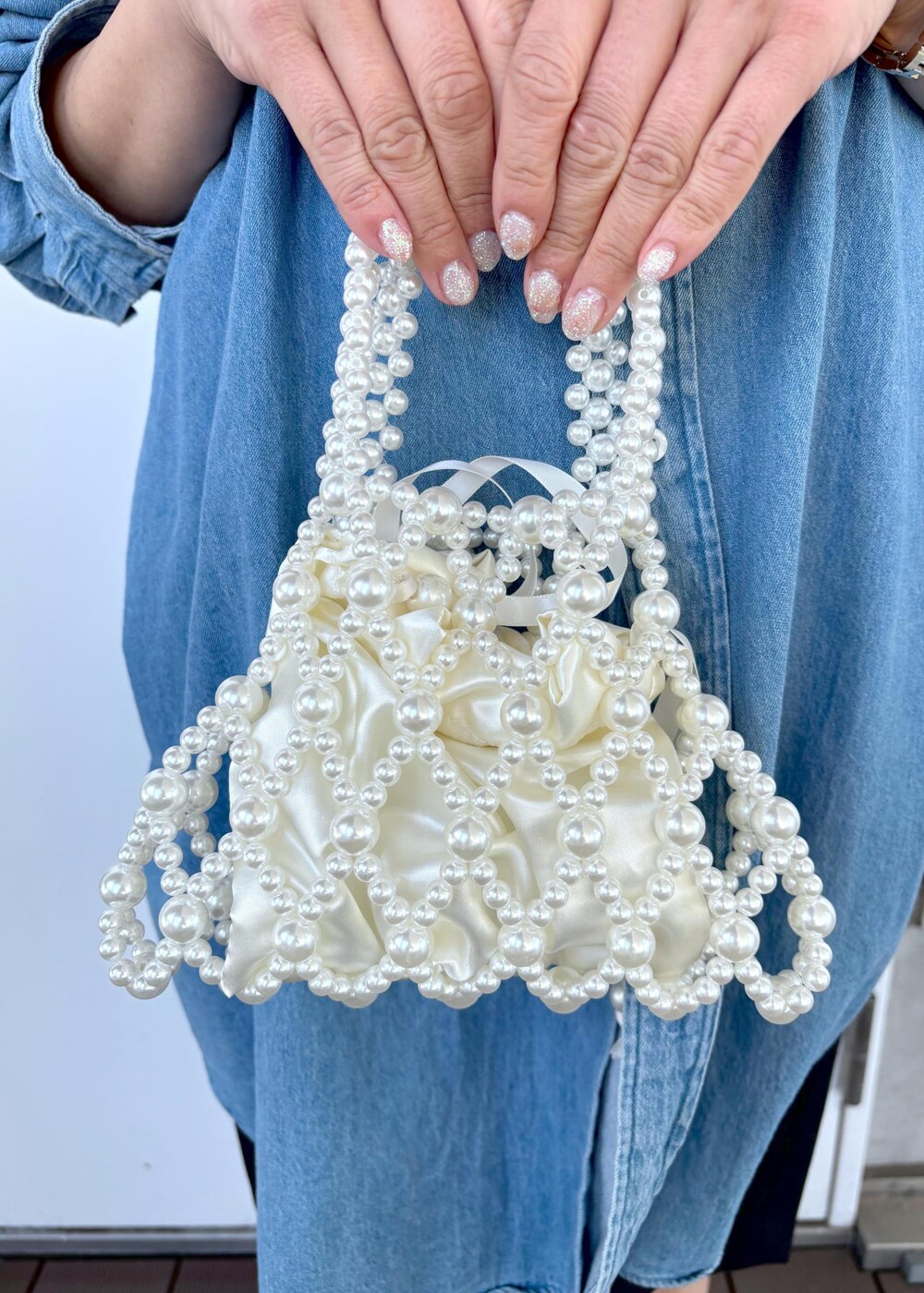 ブルー系のシャツ/ブラウス、グレー系のその他パンツ、ホワイト系のハンドバッグを着用したレディースの春コーディネートの7枚目の写真