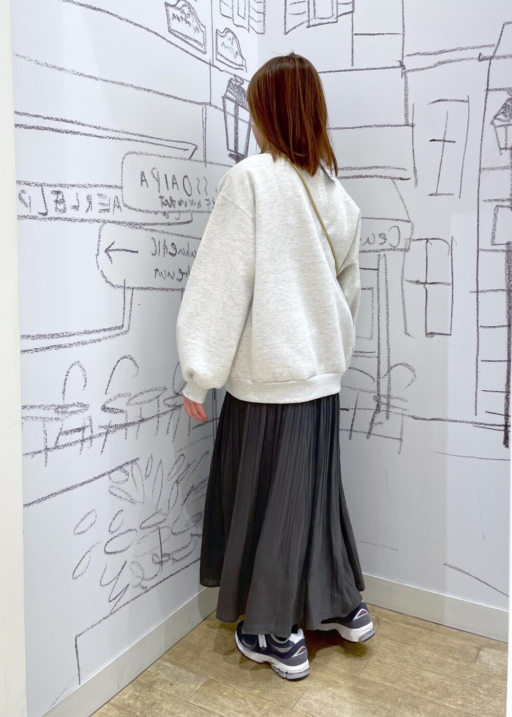 イエロー系のショルダーバッグ、ホワイト系のスウェット、グレー系のワンピースを着用したレディースの冬コーディネートの3枚目の写真