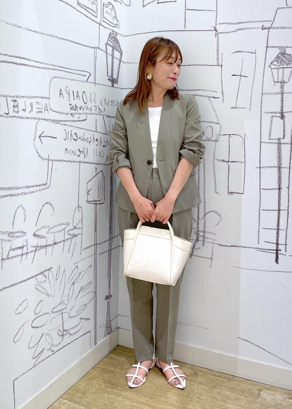 ホワイト系のタンクトップ、ホワイト系のショルダーバッグ、ブラウン系のその他パンツを着用したレディースの夏コーディネートの2枚目の写真